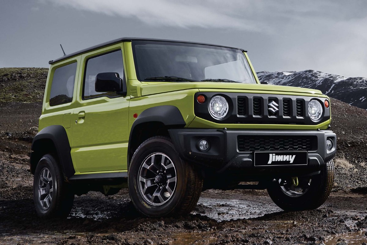 Suzuki Jimny màu vàng mui đen trên địa hình đất đá