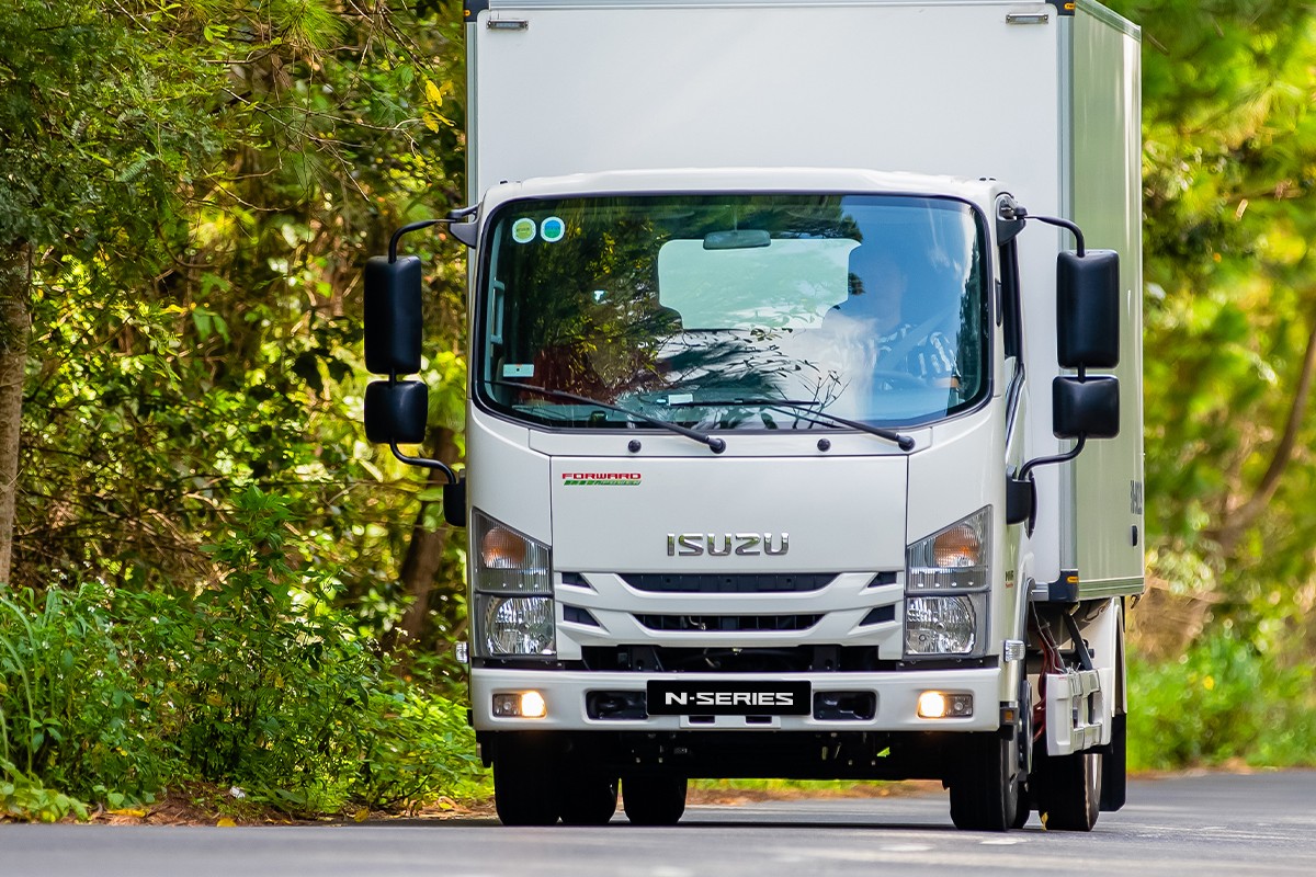 Xe tải Isuzu N-Series thùng kín chạy trên đường rừng