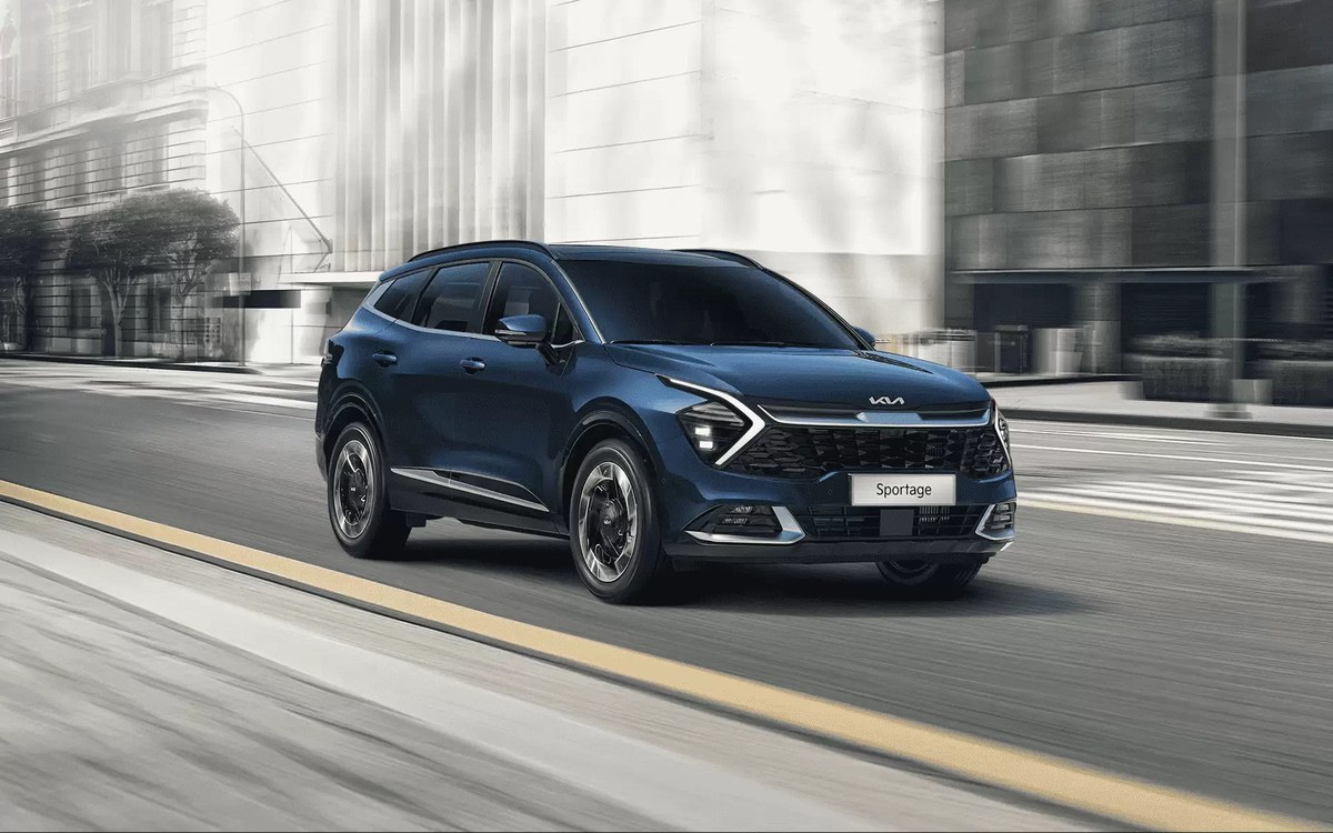 Kia Sportage màu xanh chạy trên đường