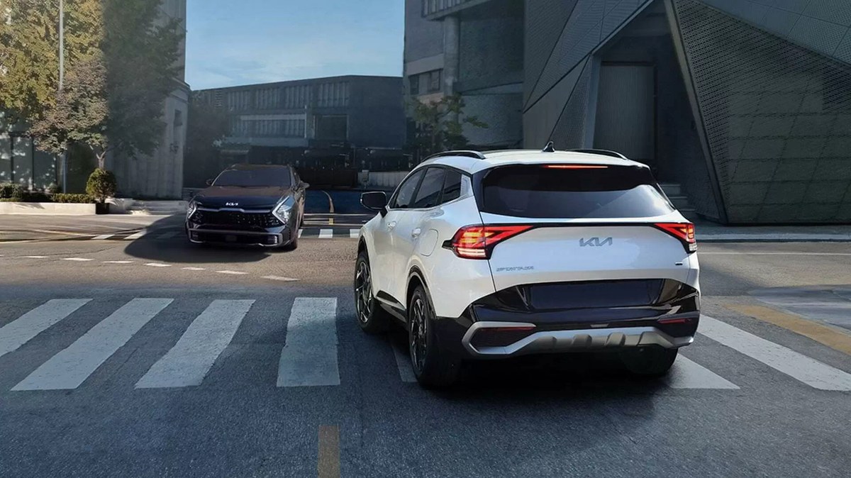 Kia Sportage màu trắng nhìn từ phía sau tại vạch qua đường
